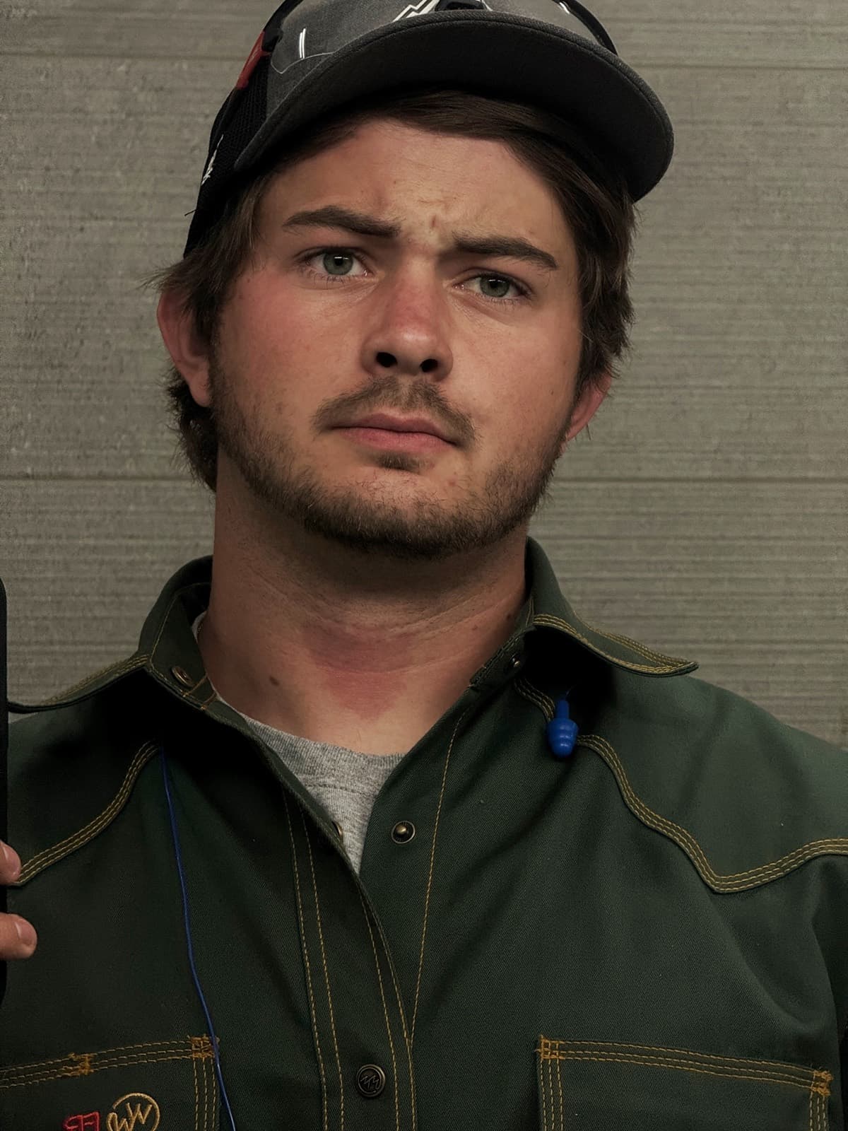 Portrait of Dylan Bird, owner of Bird Built, in his welding jacket with safety glasses on his cap