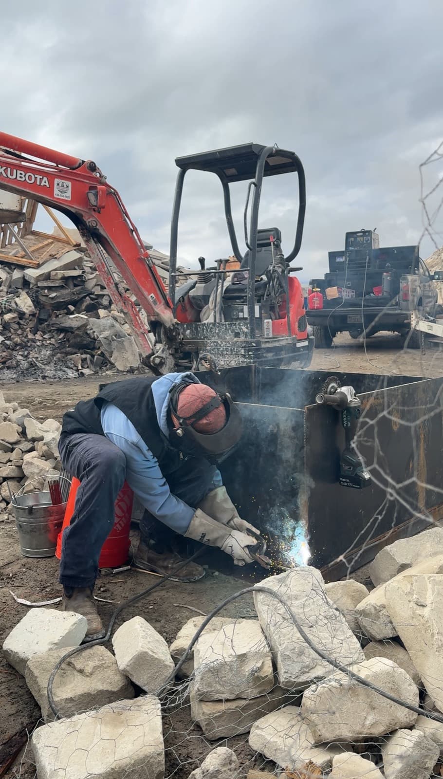 Dylan welding a heavy steel plate pallet on site at a masonry yard