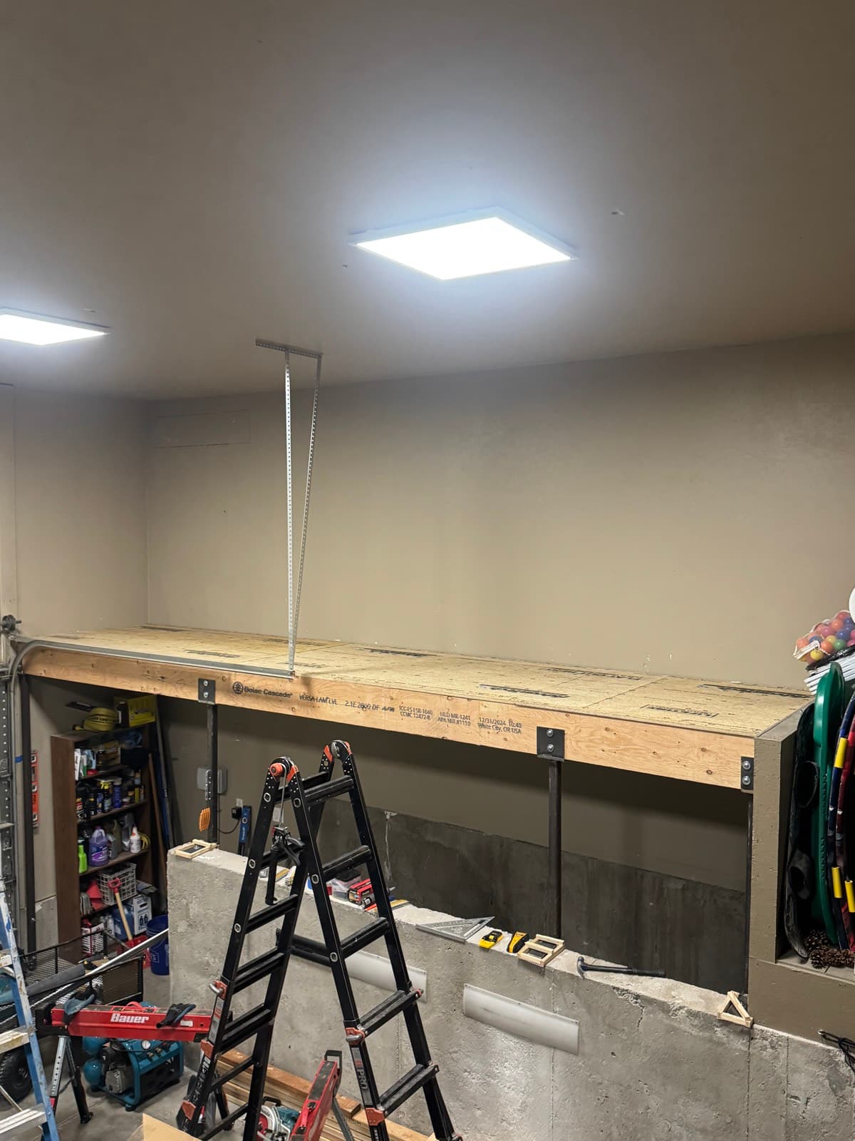 Custom steel columns with side-mounted plates supporting an LVL beam for a storage shelf